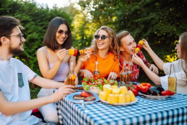 Bir grup arkadaş arka bahçede akşam yemeği partisi veriyor. Gençler dışarıda birlikte vakit geçirip bira ve barbekü içerek eğleniyorlar. Tatil, piknik, hafta sonu, doğa.