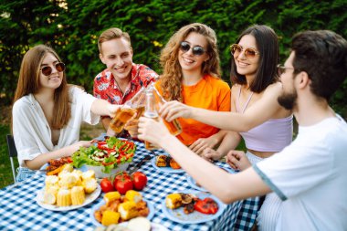 Bir grup arkadaş arka bahçede akşam yemeği partisi veriyor. Gençler dışarıda birlikte vakit geçirip bira ve barbekü içerek eğleniyorlar. Tatil, piknik, hafta sonu, doğa.