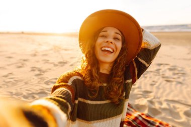 Sahilde yaşayan akıllı telefon özçekimi kullanan genç bir kadının portresi. Teknoloji ve yaşam tarzı seyahat ve seyahat kavramı