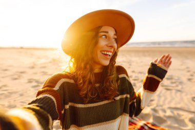 Sahilde yaşayan akıllı telefon özçekimi kullanan genç bir kadının portresi. Teknoloji ve yaşam tarzı seyahat ve seyahat kavramı