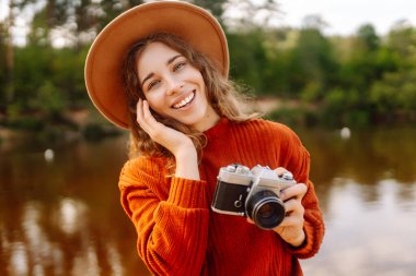 Profesyonel kameralı genç bir kadın turist doğanın fotoğrafını çekiyor. Trip, fotoğrafçılık ya da doğalı bir kız..