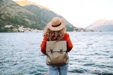 Arkaya bakan genç bayan turist şehrin rengarenk manzarasına ve dağ koyunun manzarasına hayran. Yaşam tarzı, tatil, dinlenme, aktif yaşam.