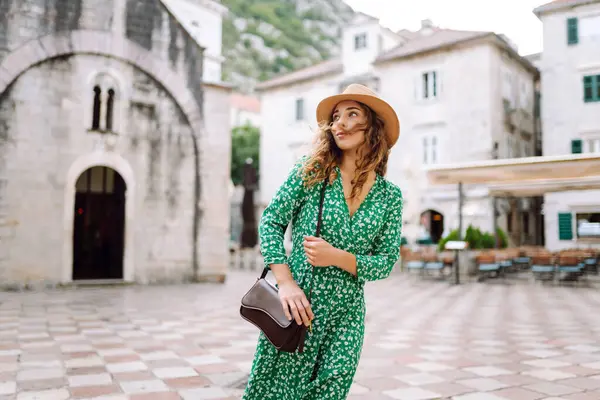 Tarihi şehir caddesinde yürüyen yazlık elbise giyen güzel bir kadın. Moda, tarz, turizm konsepti.
