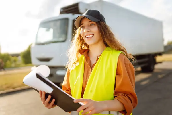 stock image Portrait of woman truck driver in casual clothes standing in front of truck vehicles. Transport industry theme. Business.