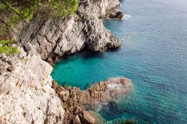 Kayaların ve gölün üstünden göz kamaştırıcı bir manzara. Sabah Dağ Gölü 'nün kayalık kıyısı. Seyahat için ünlü bir yer.