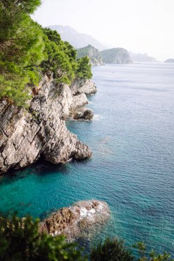 Kayaların ve gölün üstünden göz kamaştırıcı bir manzara. Sabah Dağ Gölü 'nün kayalık kıyısı. Seyahat için ünlü bir yer.