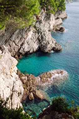 Kayaların ve gölün üstünden göz kamaştırıcı bir manzara. Sabah Dağ Gölü 'nün kayalık kıyısı. Seyahat için ünlü bir yer.