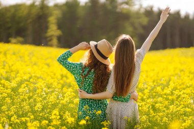 Çiçek açan alandaki iki çekici kadın. Doğa, tatil, rahatlama ve yaşam tarzı. Yaz manzarası.