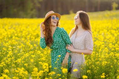 Çiçek açan alandaki iki çekici kadın. Doğa, tatil, rahatlama ve yaşam tarzı. Yaz manzarası.