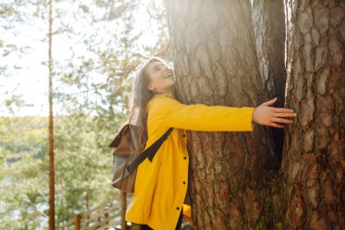 Genç turist kadın göl kenarında bahar gününün tadını çıkarıyor. Aktif yaşam tarzı. Özgürlük kavramı, seyahat, doğa, hafta sonu.