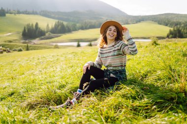 Yeşil çimen tarlasında yürüyen mutlu kadın manzaraya hayran. Macera ve seyahat keşfi