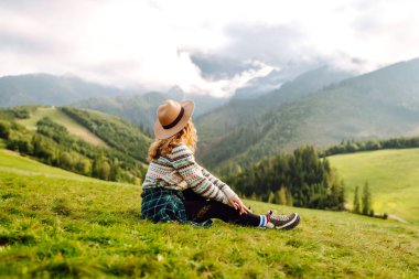 Yeşil çimen tarlasında yürüyen mutlu kadın manzaraya hayran. Macera ve seyahat keşfi