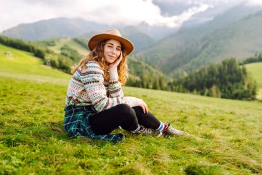 Yeşil çimen tarlasında yürüyen mutlu kadın manzaraya hayran. Macera ve seyahat keşfi