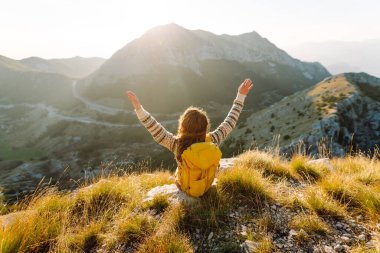 Kadın Gezgin, sırt çantasıyla dağlarda durup manzaraya hayran. Seyahat yaşam tarzı. Açık havada yaz tatili kavramları.