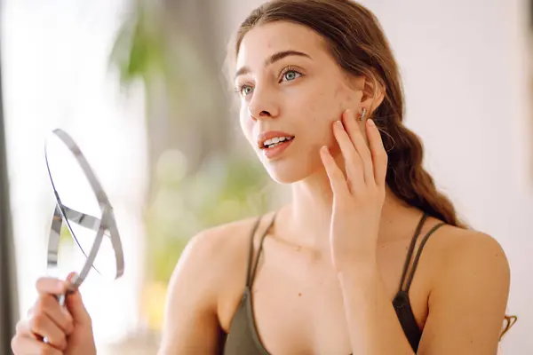 Stock image Portrait of a young woman without makeup with Acne skin. Skin problems, first mimic wrinkles or acne pimples, annoyed by blackheads.