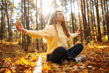 Huzurlu doğal ormanda yoga yapan genç bir kadın. Yaşam tarzı ve meditasyon konsepti.