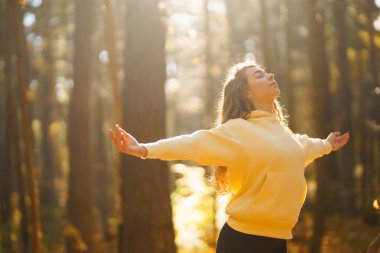 Huzurlu doğal ormanda yoga yapan genç bir kadın. Yaşam tarzı ve meditasyon konsepti.