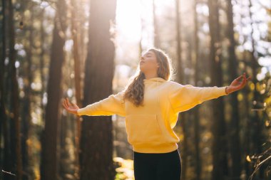 Huzurlu doğal ormanda yoga yapan genç bir kadın. Yaşam tarzı ve meditasyon konsepti.
