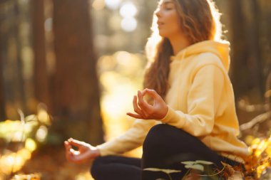 Huzurlu doğal ormanda yoga yapan genç bir kadın. Yaşam tarzı ve meditasyon konsepti.