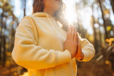 Huzurlu doğal ormanda yoga yapan genç bir kadın. Yaşam tarzı ve meditasyon konsepti.