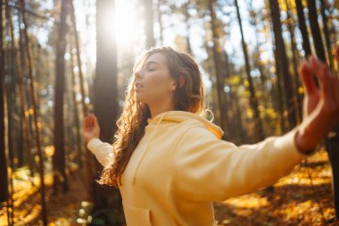 Huzurlu doğal ormanda yoga yapan genç bir kadın. Yaşam tarzı ve meditasyon konsepti.