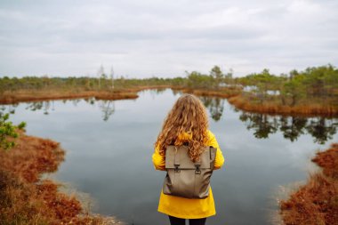 Ulusal parkta yürüyen sonbahar doğa yürüyüşçüsü kadın. Sırt çantalı kadın doğanın güzelliğinin tadını çıkarıyor. Yaşam tarzı konsepti, doğa yürüyüşü..