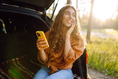 Mutlu kadın yolculuğunda selfie çekiyor. Güzel bir kadın yerel doğayı keşfediyor. Arabayla seyahat et..