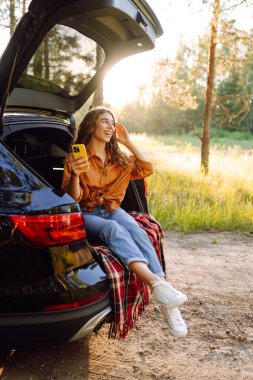 Mutlu kadın yolculuğunda selfie çekiyor. Güzel bir kadın yerel doğayı keşfediyor. Arabayla seyahat et..