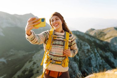 Selfie, videodaki kadın ve dağ seyahati tatili. Doğa özgürlüğü macerası, mutlu tatiller. Günlük tutma.