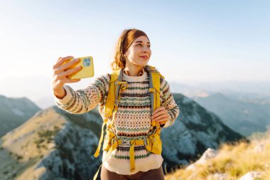 Selfie, videodaki kadın ve dağ seyahati tatili. Doğa özgürlüğü macerası, mutlu tatiller. Günlük tutma.