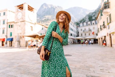 Genç bayan turist şehir merkezinde bir meydanın etrafında yürüyor. Yaşam tarzı kavramı, tatil, moda, seyahat.