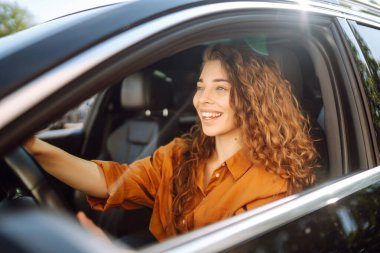 Araba süren genç bir kadın portresi. Araba kullanan genç bir gezgin. Araba yolculuğu, yaşam tarzı konsepti..