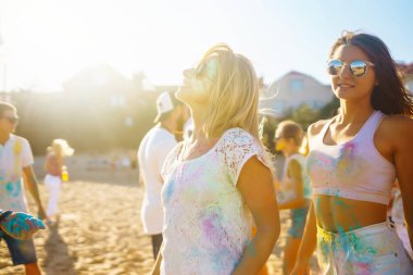 Holi festivali. Bir grup arkadaş pudra boyasıyla eğleniyor. Plaj partisi. Arkadaşlık, dinlenme, tatil.