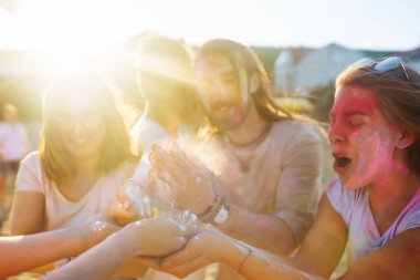 Holi festivali. Bir grup arkadaş pudra boyasıyla eğleniyor. Plaj partisi. Arkadaşlık, dinlenme, tatil.