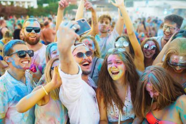 Holi festivali. Bir grup arkadaş pudra boyasıyla eğleniyor. Plaj partisi. Arkadaşlık, dinlenme, tatil.