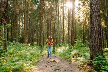Genç kadın orman manzarasının tadını çıkarıyor. Seyahatler. Aktif yaşam tarzı. Yürüyüş.