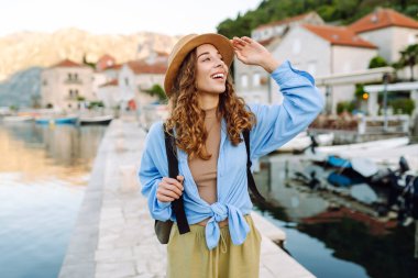 Genç bir kadın şehrin manzarasına bakıyor, yazın yeni bir şehri keşfediyor. Avrupa seyahati. Yaşam tarzı, tatil, turizm, doğa, aktif yaşam.