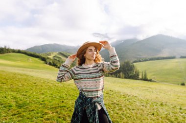 Yeşil çimen tarlasında yürüyen sevimli bir kadın manzaraya hayran. Doğanın tadını çıkarıyorum. Macera ve seyahat. 
