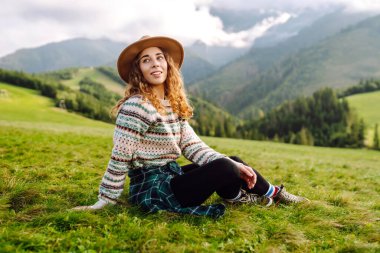 Yeşil çimen tarlasında yürüyen sevimli bir kadın manzaraya hayran. Doğanın tadını çıkarıyorum. Macera ve seyahat. 