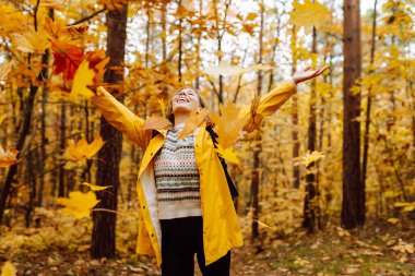 Sırt çantası taşıyan aktif genç bir kadın güzel bir sonbahar gününün tadını çıkarıyor. Sonbahar manzarası. Sakinlik ve sükunet. Seyahat, turizm konsepti.