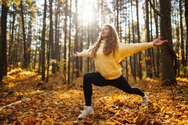 Huzurlu doğal ormanda sabah yoga ve meditasyonu. Yoga egzersizi yapan güzel bir kadın. Heather yaşam tarzı.