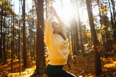 Huzurlu doğal ormanda sabah yoga ve meditasyonu. Yoga egzersizi yapan güzel bir kadın. Heather yaşam tarzı.