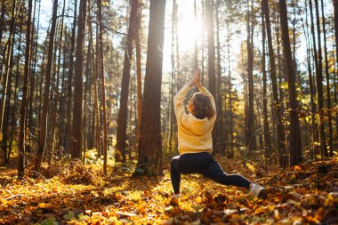 Huzurlu doğal ormanda sabah yoga ve meditasyonu. Yoga egzersizi yapan güzel bir kadın. Heather yaşam tarzı.
