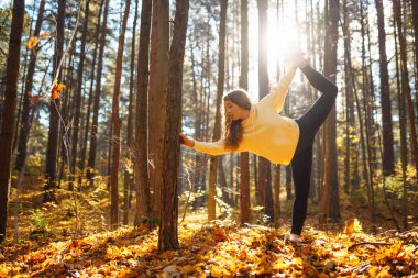 Huzurlu doğal ormanda sabah yoga ve meditasyonu. Yoga egzersizi yapan güzel bir kadın. Heather yaşam tarzı.