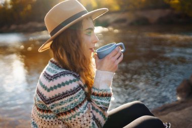 Termostan çay ya da kahve içen kadın portresi. Sakinlik ve sükunet. Doğanın tadını çıkar.