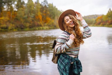 Kadın doğayla çevrili yeni ve büyülü yerleri keşfediyor. Dişi yürüyüşçü orman deresini geçiyor. Yürüyüş, seyahat, tatil konsepti.