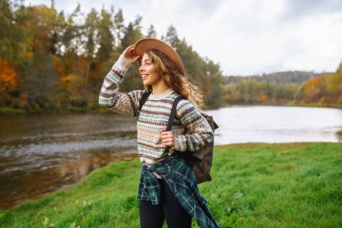 Kadın doğayla çevrili yeni ve büyülü yerleri keşfediyor. Dişi yürüyüşçü orman deresini geçiyor. Yürüyüş, seyahat, tatil konsepti.