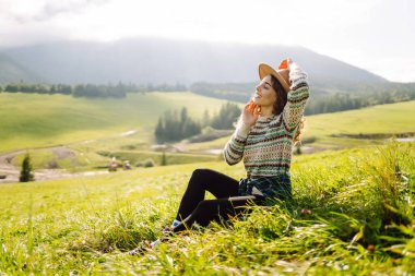 Genç gezgin kadın, gündüz vakti şapka takıp manzaranın tadını çıkarıyordu. Seyahat, doğa konsepti.