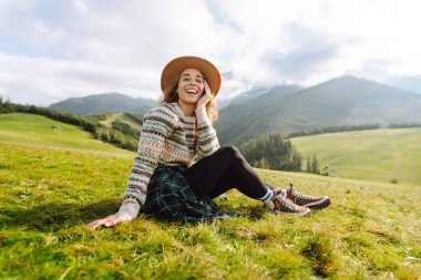 Genç gezgin kadın, gündüz vakti şapka takıp manzaranın tadını çıkarıyordu. Seyahat, doğa konsepti.