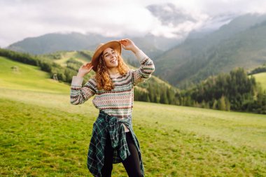 Genç gezgin kadın, gündüz vakti şapka takıp manzaranın tadını çıkarıyordu. Seyahat, doğa konsepti.